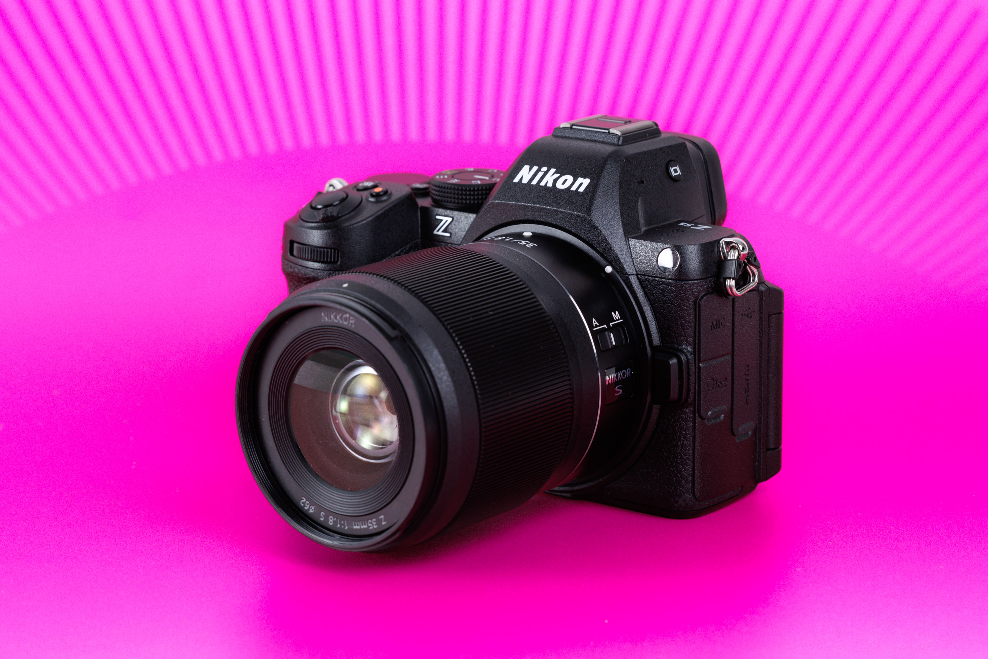Nikon Z5 II mirrorless camera with NIKKOR Z 35mm f/1.8 S lens against a bright pink studio background
