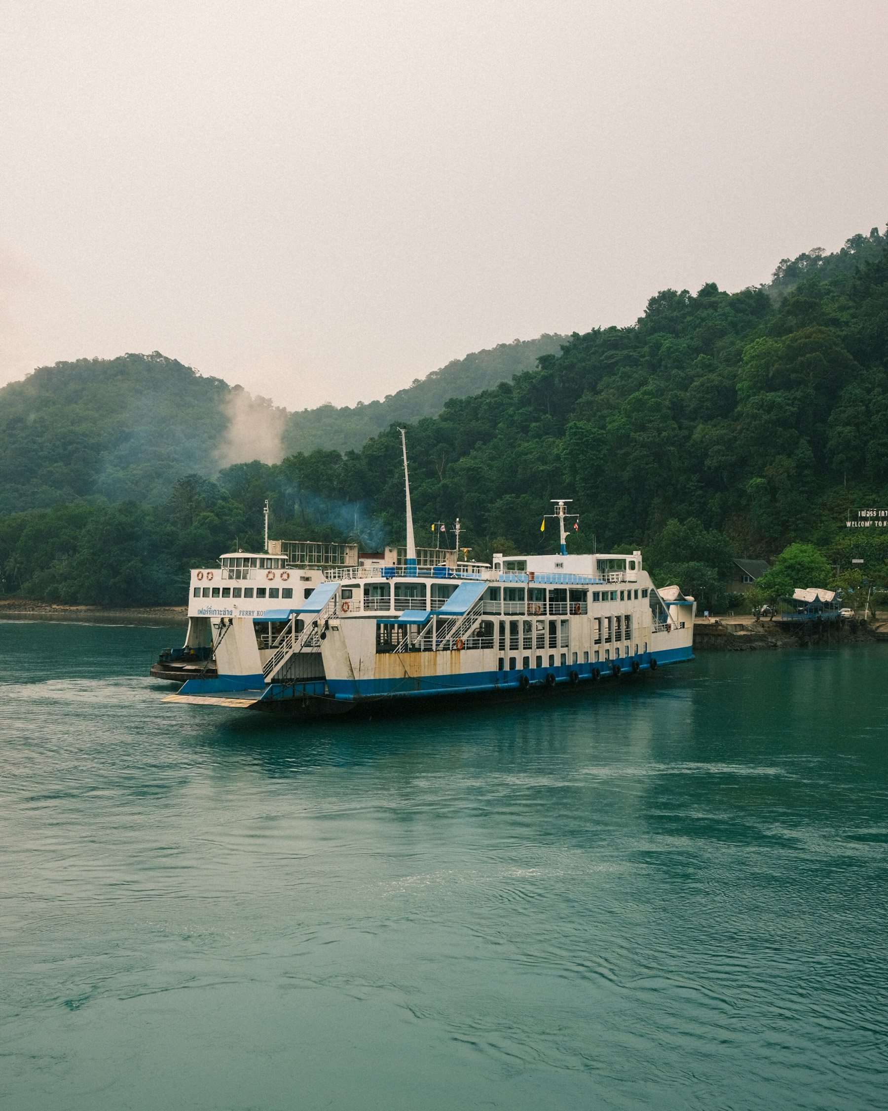 Damper auf dem Wasser in Koh Chang, im Hintergrund grüne Wälder, aufgenommen von Michael Schulz mit der Fujifilm X100V