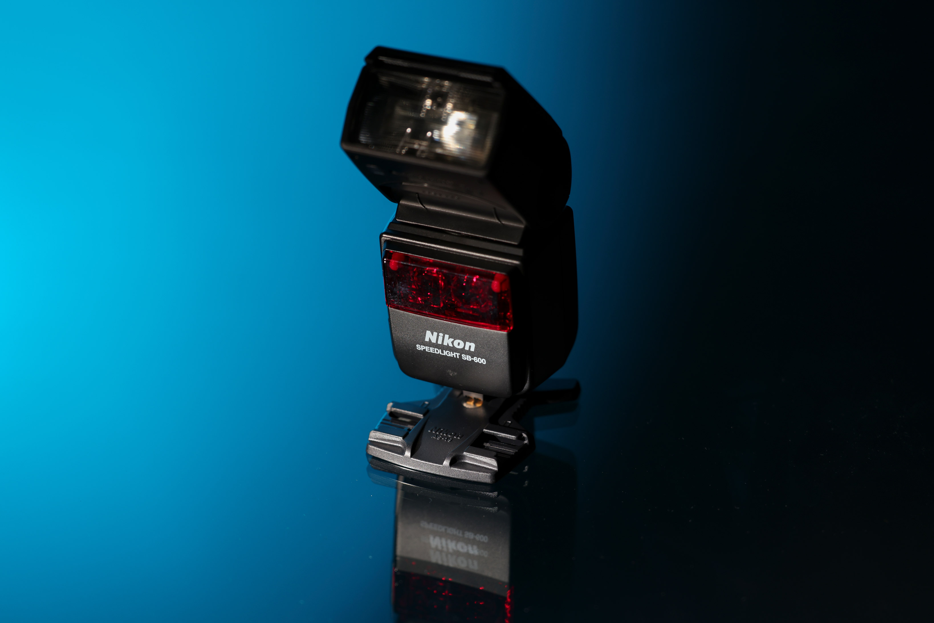 Nikon SB-600 Speedlight against a blue and black background.