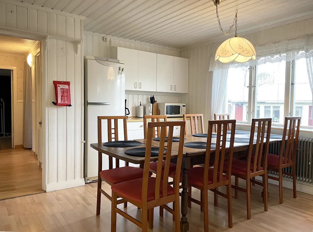 A picture of the kitchen featuring the dining table and refrigerator.