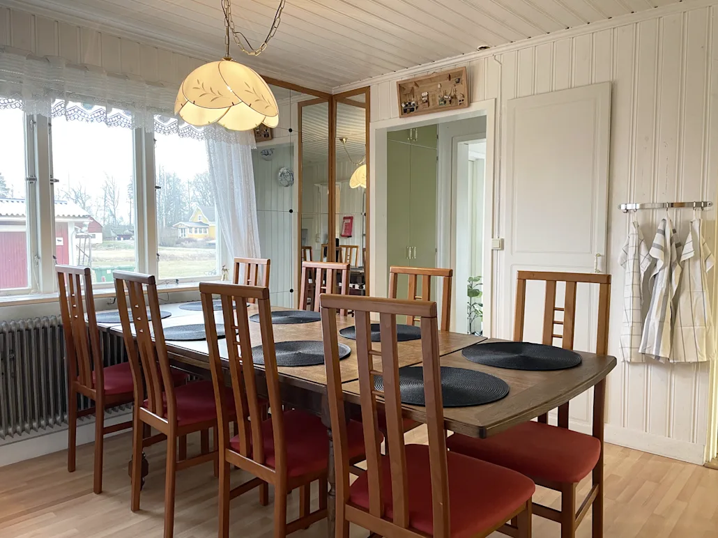 A picture of the kitchen including the dining table and a view of the primary hall.