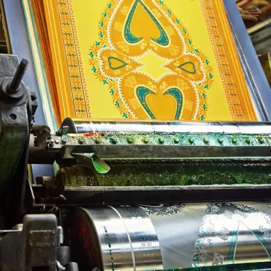 Yellow java fabric being printed on a roller