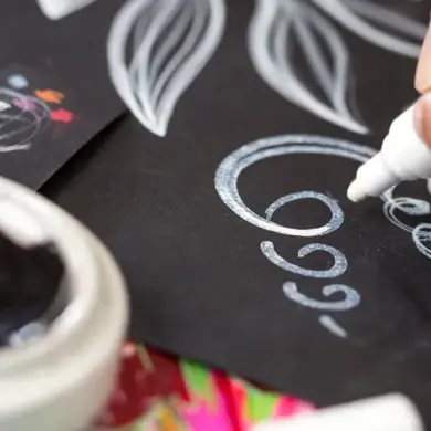 A Vlisco creative designer drawing patterns on black paper