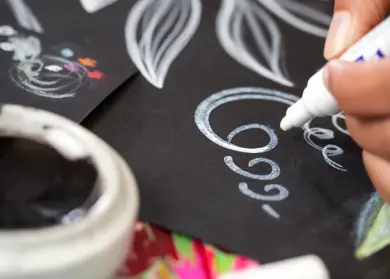 Un designer créatif de Vlisco dessine des motifs sur du papier noir