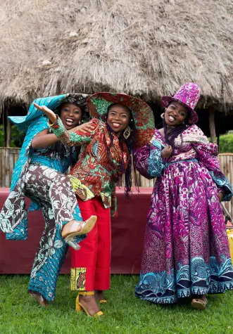 Trois femmes africaines de la Cité de la Joie portant des tenues confectionnées à partir de tissus wax Vlisco