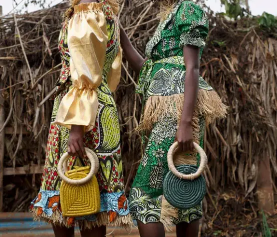 Deux femmes africaines de la Cité de la Joie portant des tenues confectionnées à partir de tissus wax Vlisco