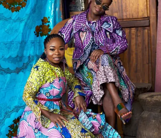 Deux femmes africaines de la Cité de la Joie portant des tenues confectionnées à partir de tissus wax Vlisco