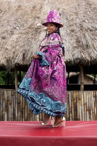 Une femme africaine de la Cité de la Joie portant des tenues confectionnées à partir de tissus wax Vlisco