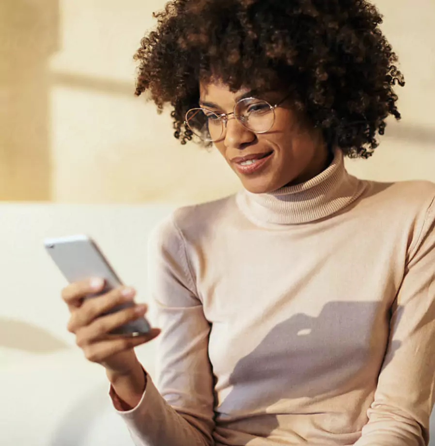 Photo of woman in glasses looking at her smartphone