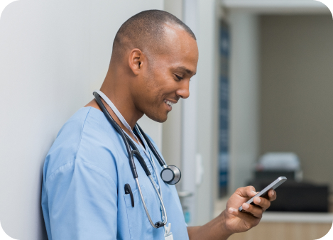 Doctor using mobile phone and smiling