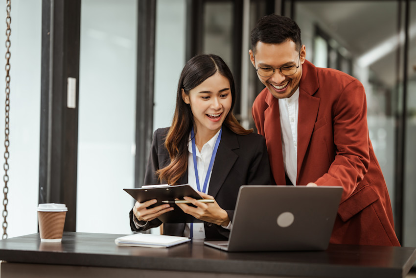 HR team standing over laptop.