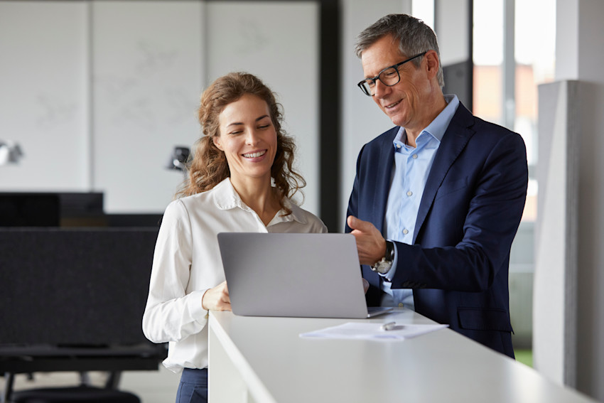 Two employees looking at laptop