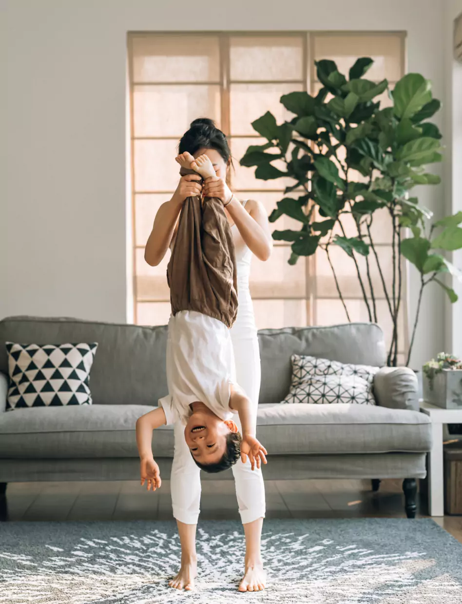 Woman playing with child holding them upside down