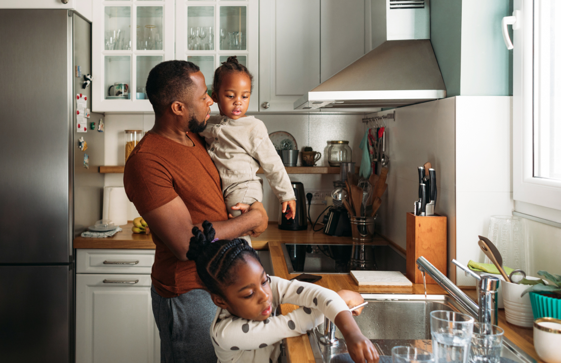 Photo of a father with daughters on the kitchen