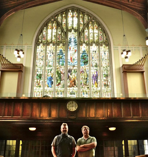 Paul Veldman and Leonard Stannard standing in front of the stained-glass window at Copperlight