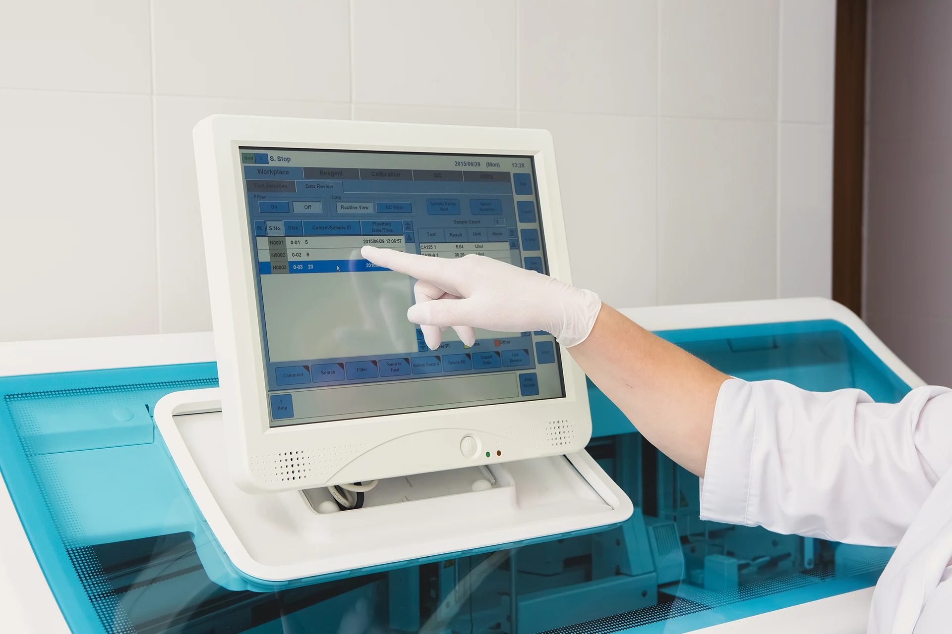 A technician using a touchscreen monitor for blood gas analysis testing.