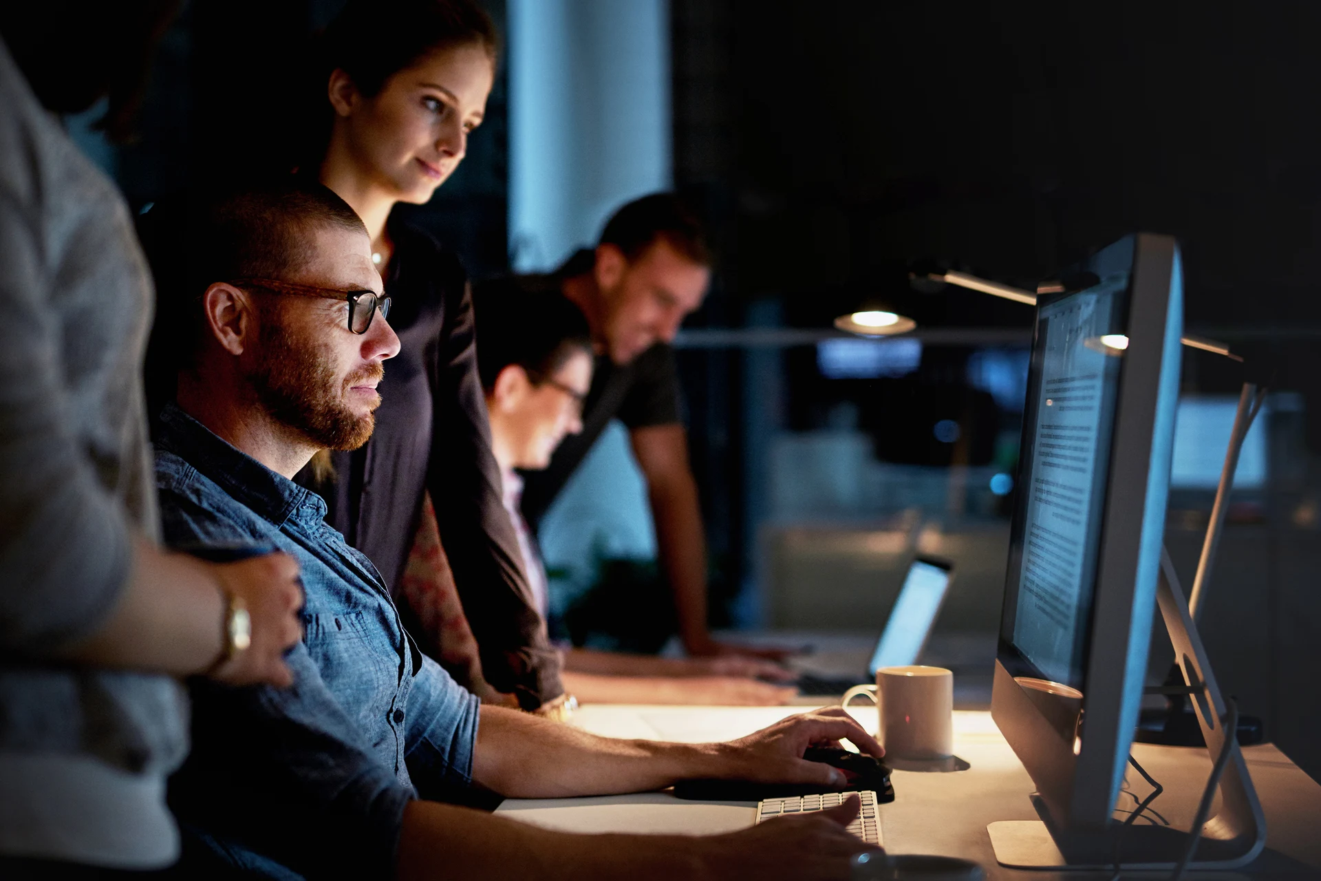 Team collaborating on a data quality project at a dimly lit workspace.