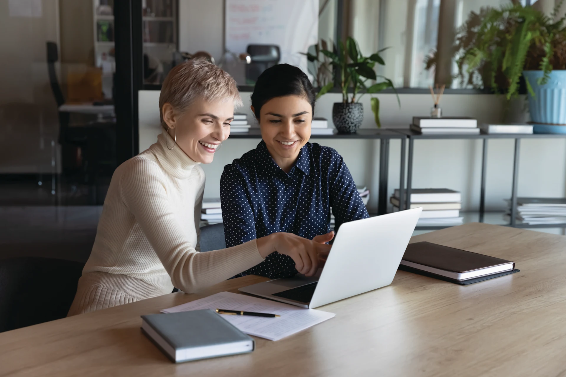 Women collaborating on laptop for Enliven initiative diversity program