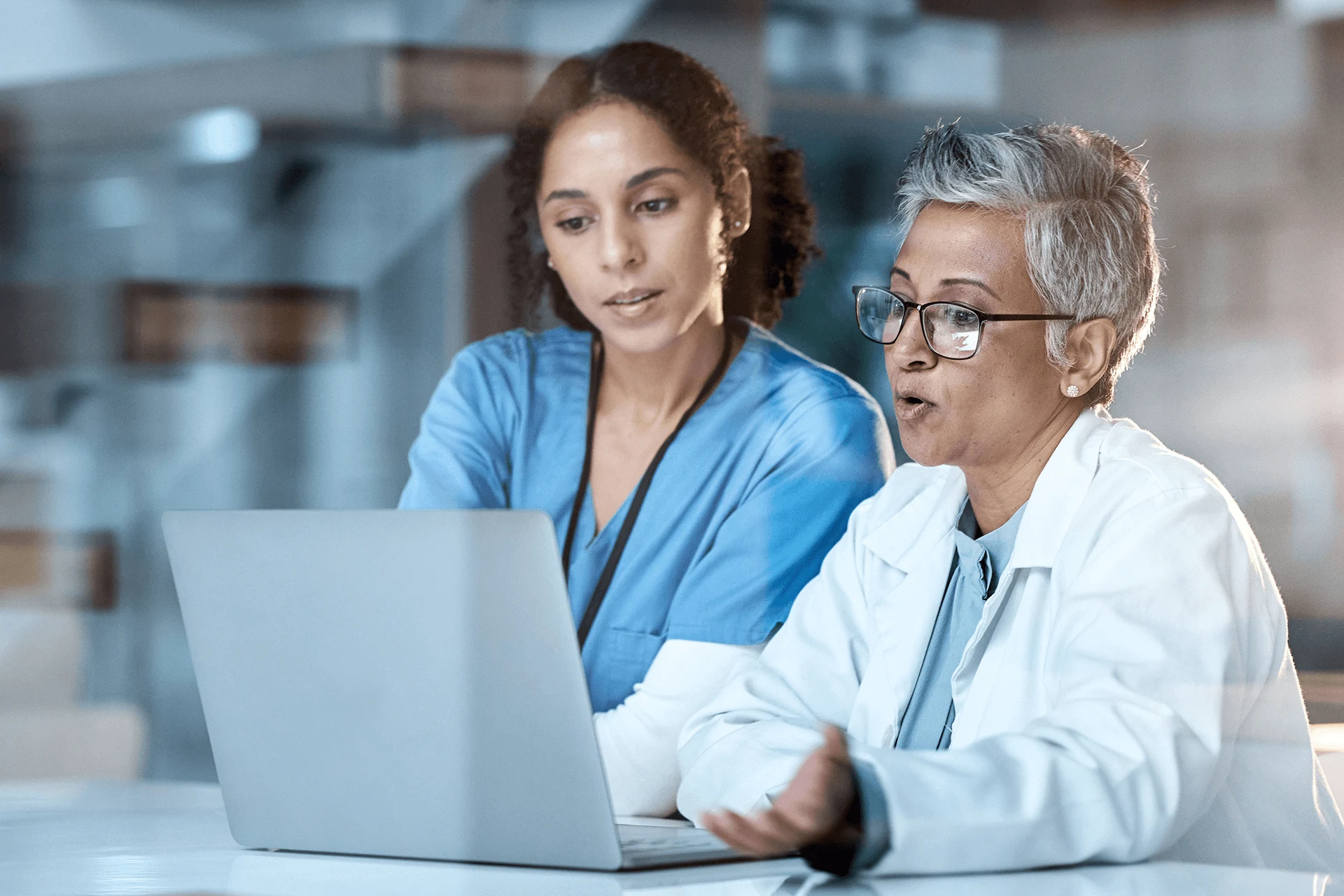 Healthcare professionals discussing AI technology over a laptop