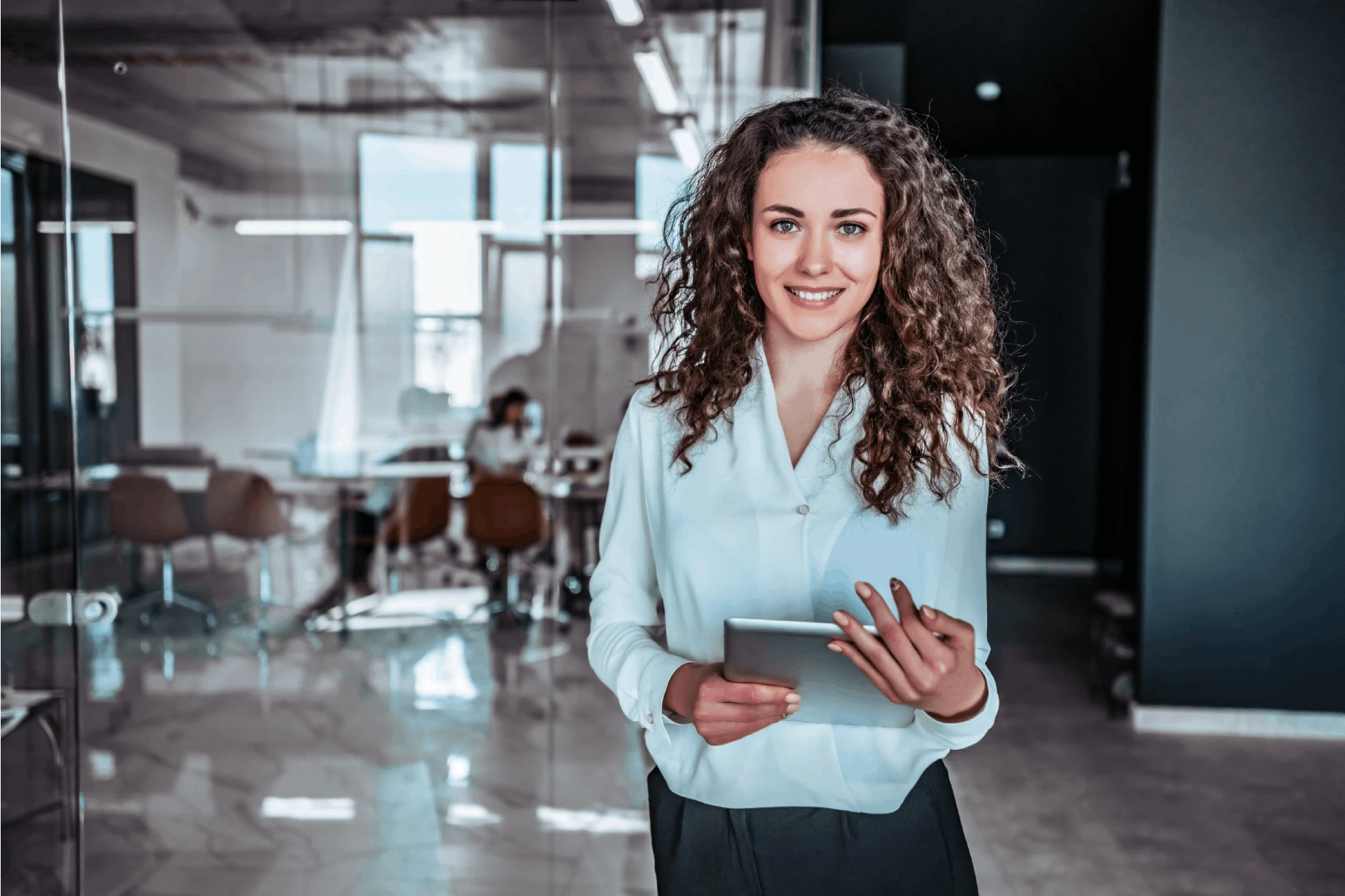 Professional woman holding a tablet in a modern office environment