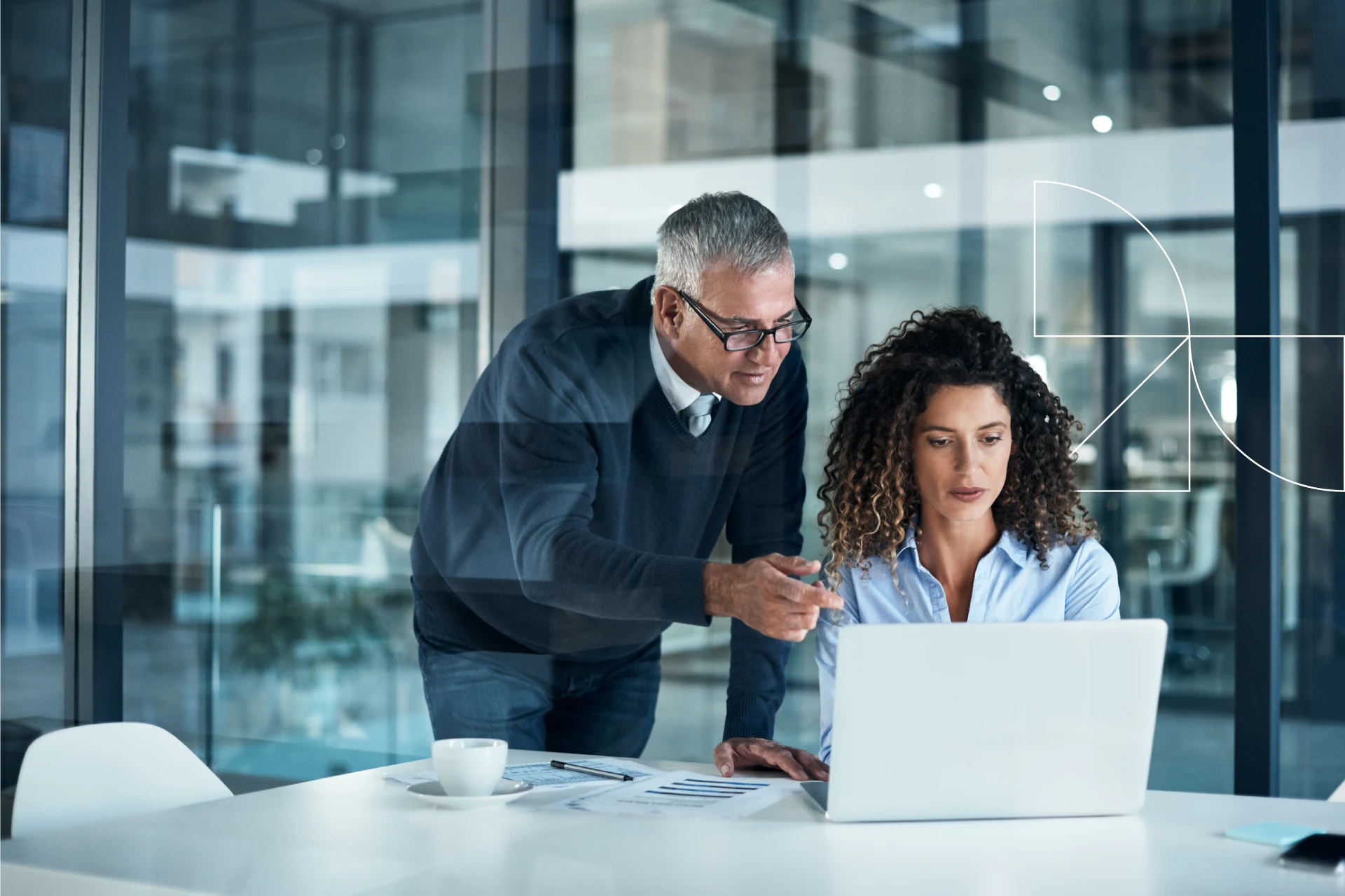 Business professionals collaborating over a laptop in a modern office setting.