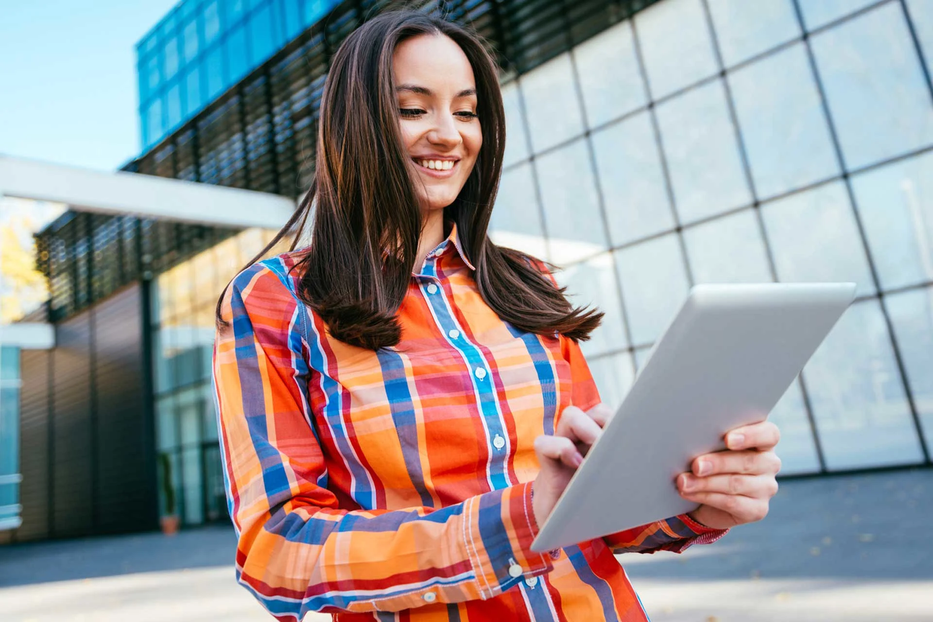 Professional using a tablet outdoors, relevant to cloud-native transformation.