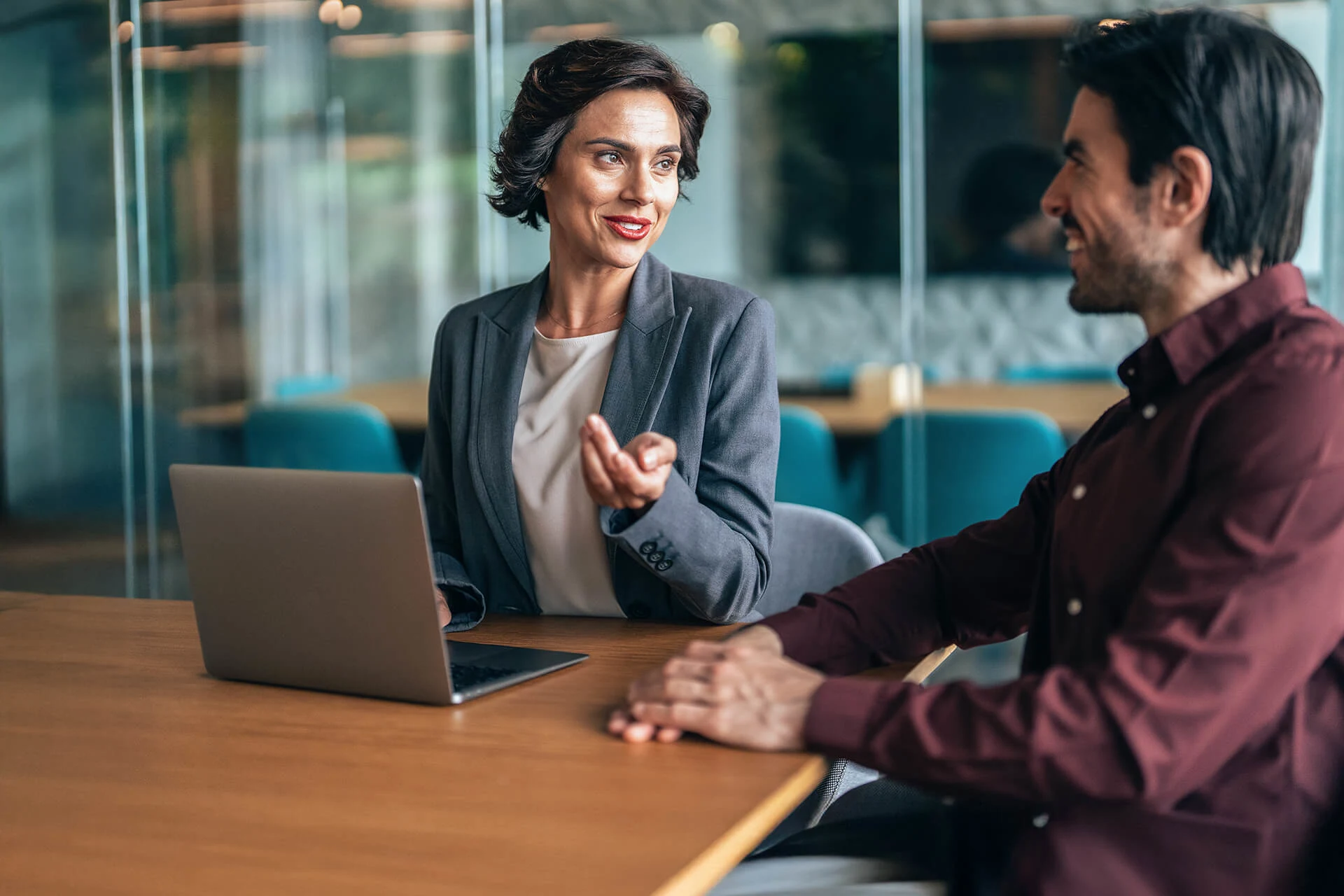 Business professionals discussing over a laptop in a modern office setting