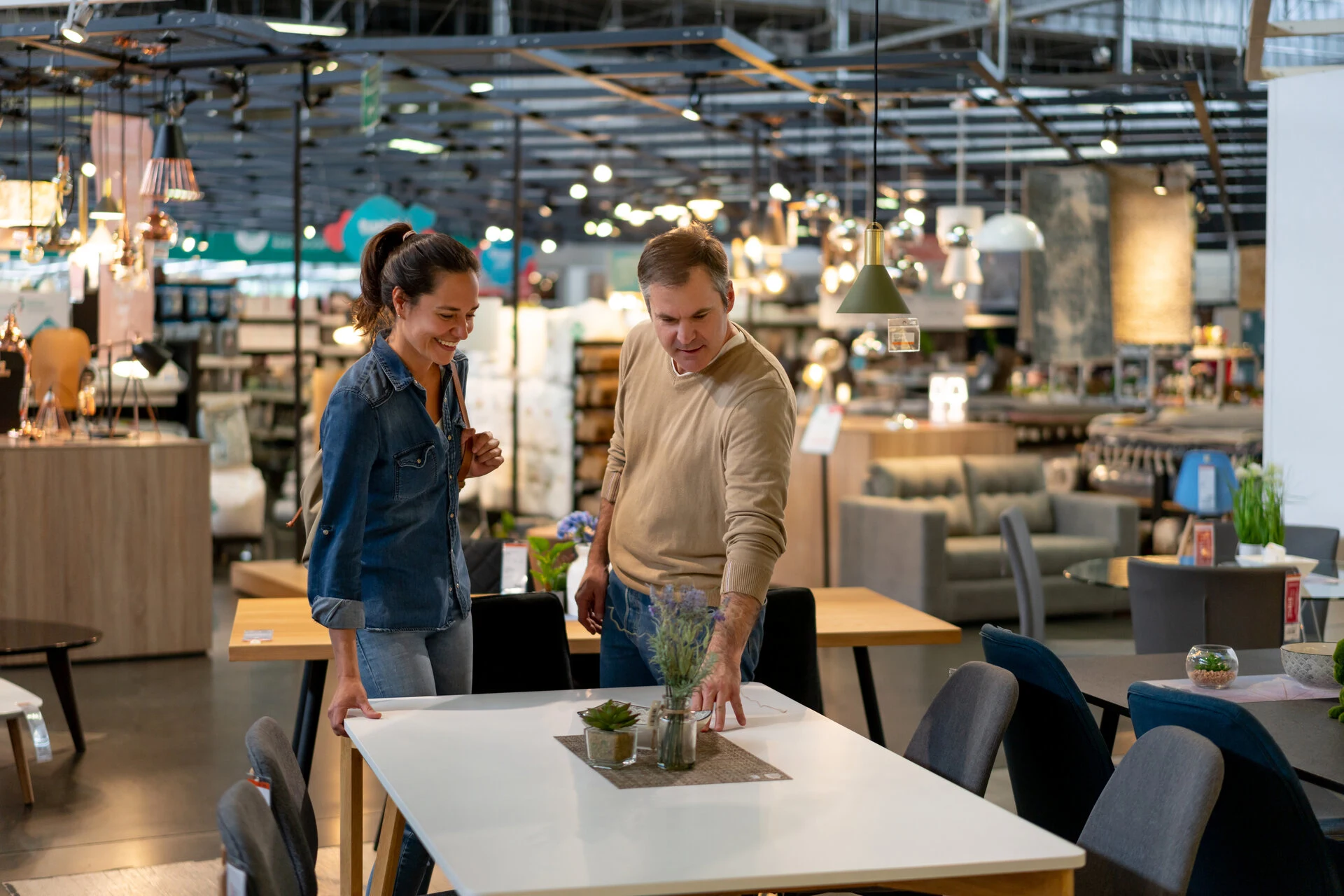 Two people discussing a table setup in a home furnishings store.