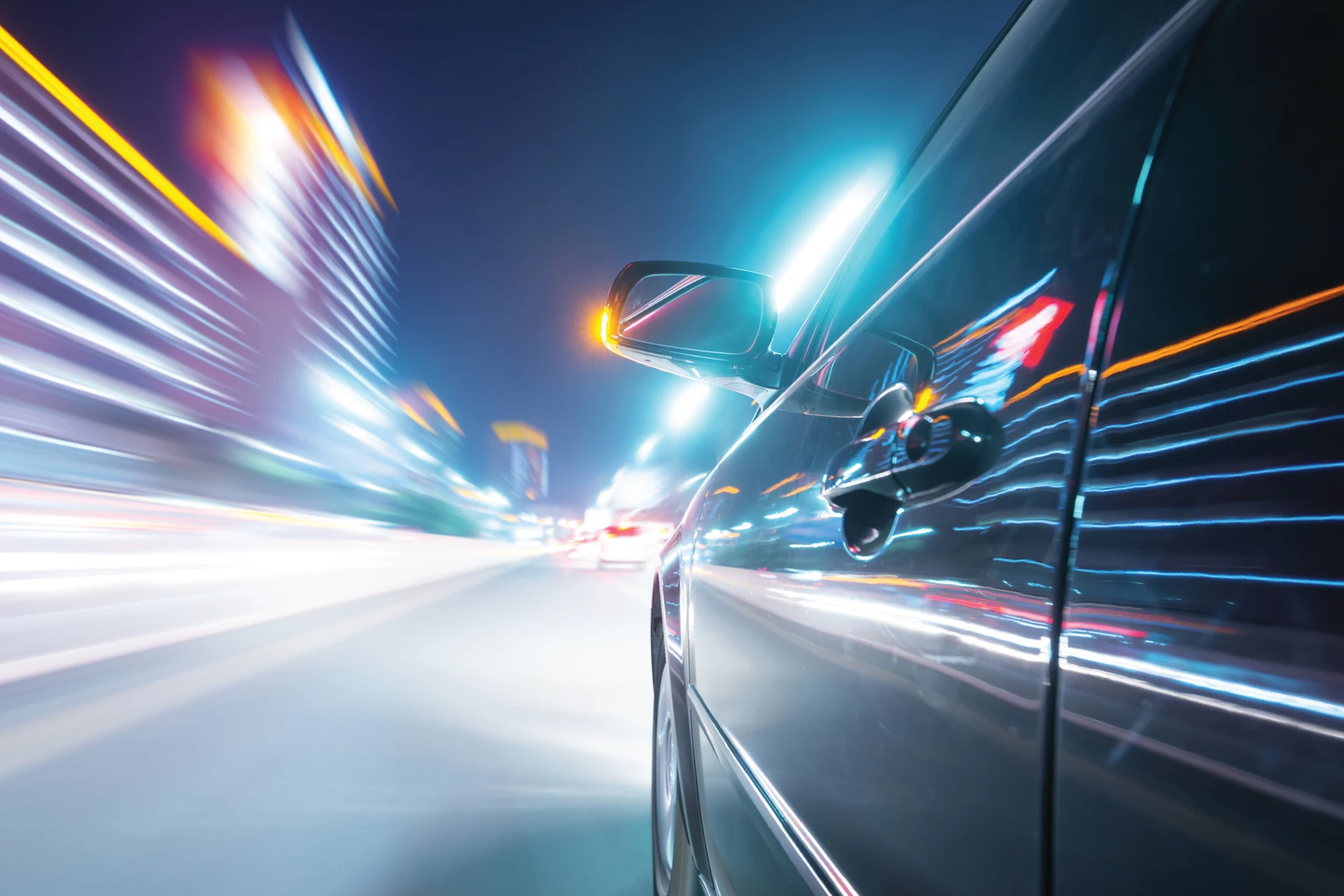 Car side view in motion at night, illustrating usage-based insurance concept.