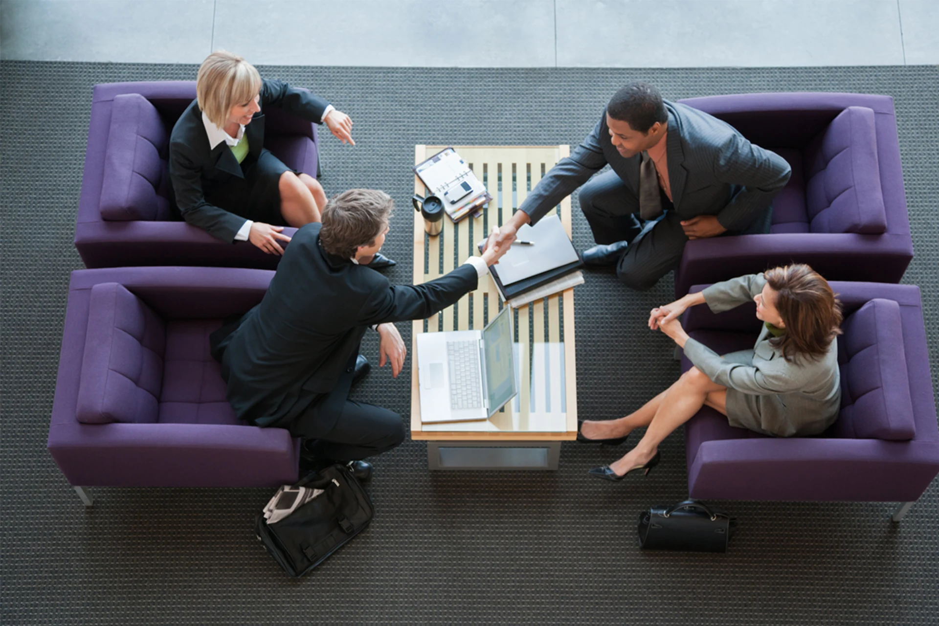 Business professionals meeting and shaking hands in a modern office