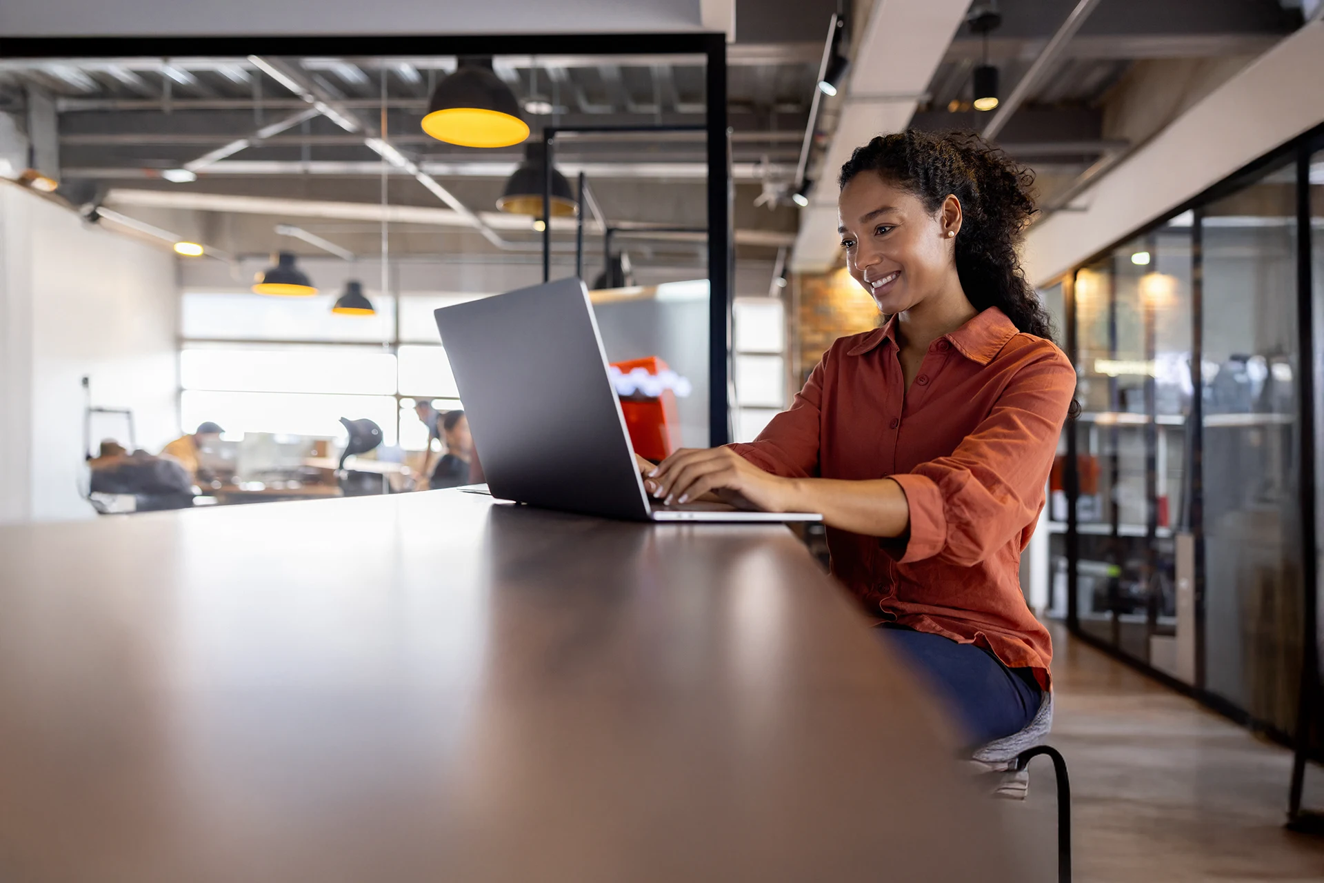 Professional working on a laptop in a collaborative workplace
