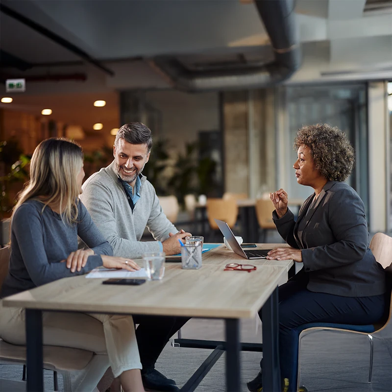 Team discussion around a table with laptop focusing on modern insurance technology