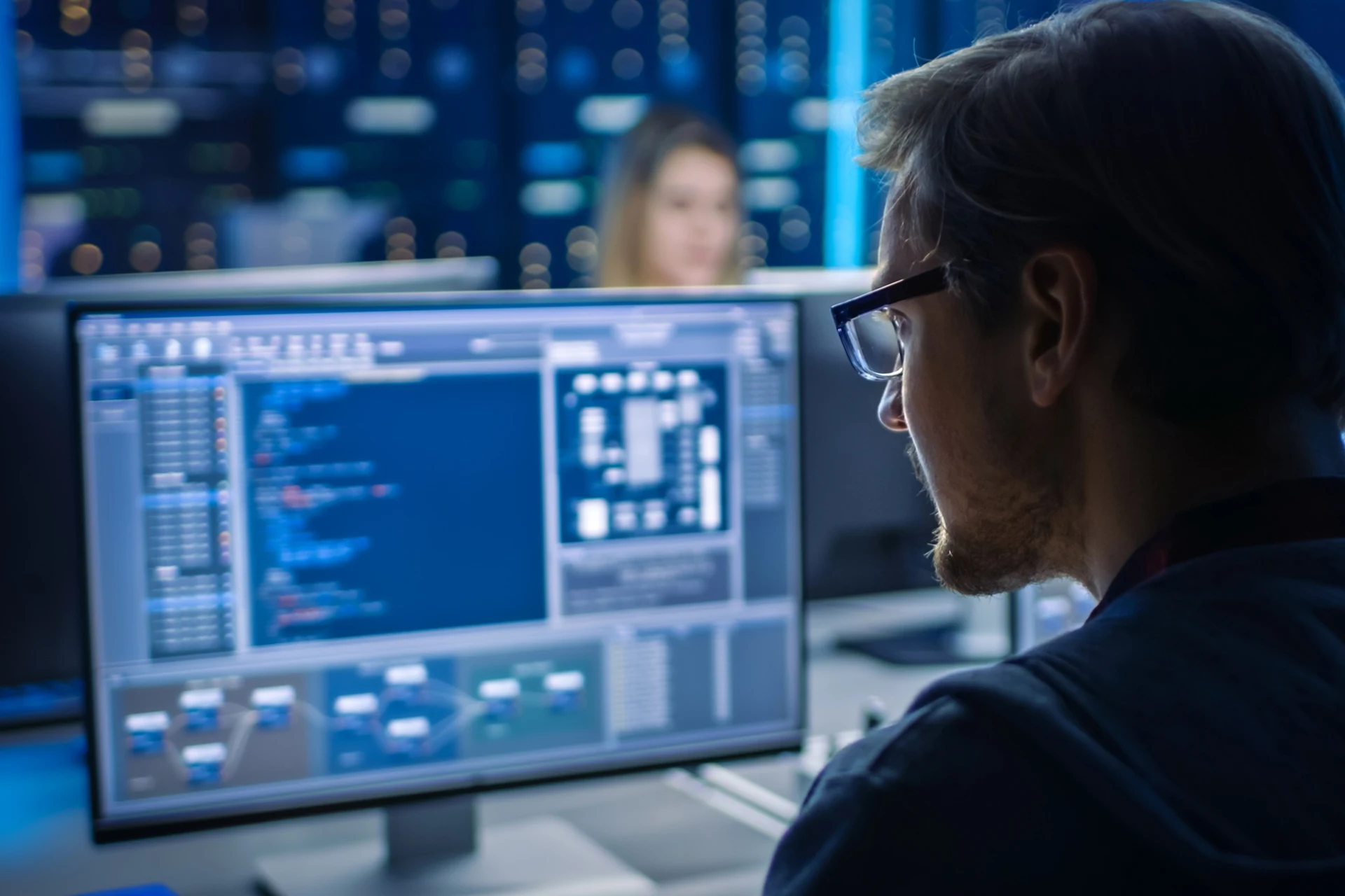 Professional reviewing code on a computer screen in a tech environment