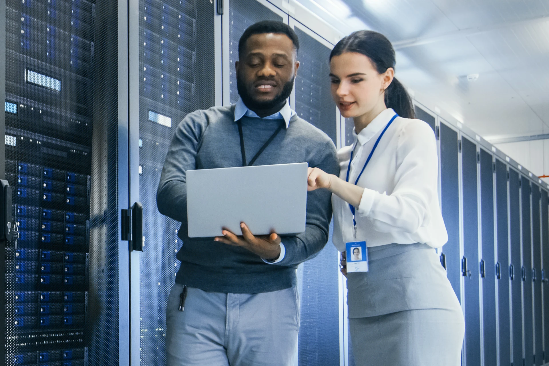 Two professionals discussing data storage solutions in a server room.