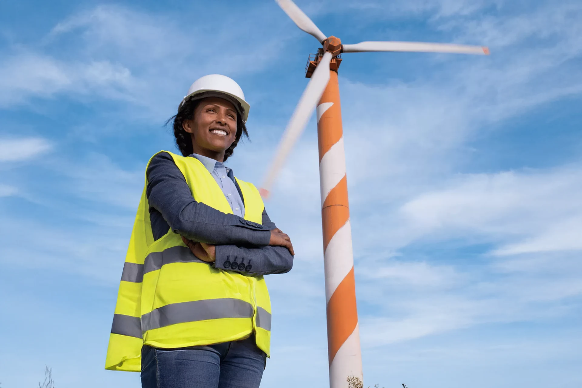 Professional in safety gear stands near a wind turbine in South Africa.