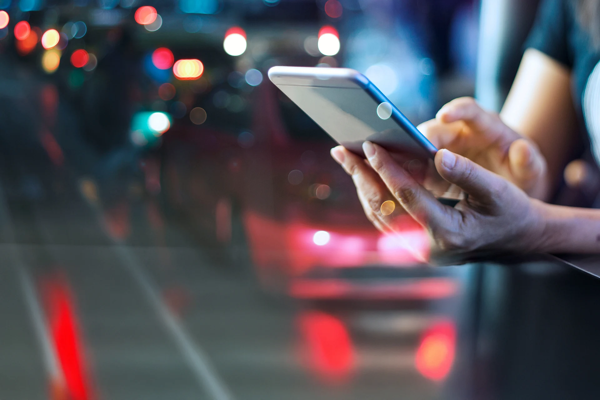 Person using a smartphone in a blurred urban environment for financial services applications