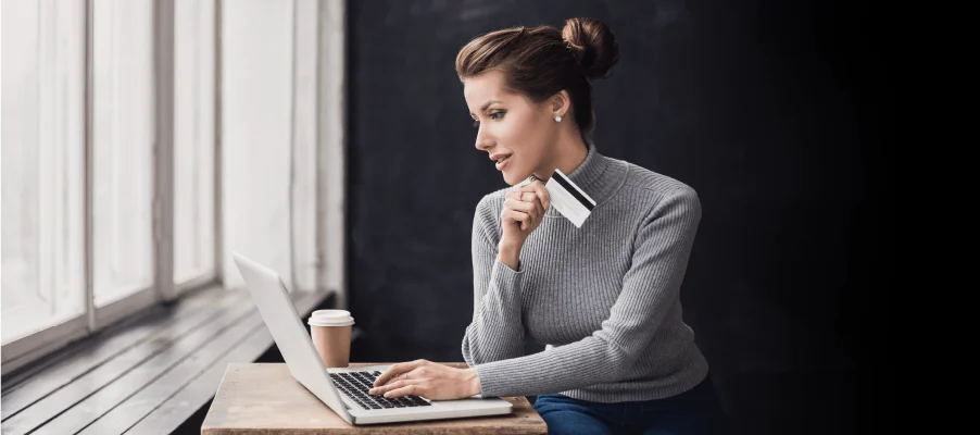 Person shopping online with a credit card and laptop at home