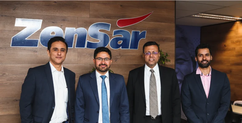 Four corporate professionals posing in front of Zensar logo Cape Town office
