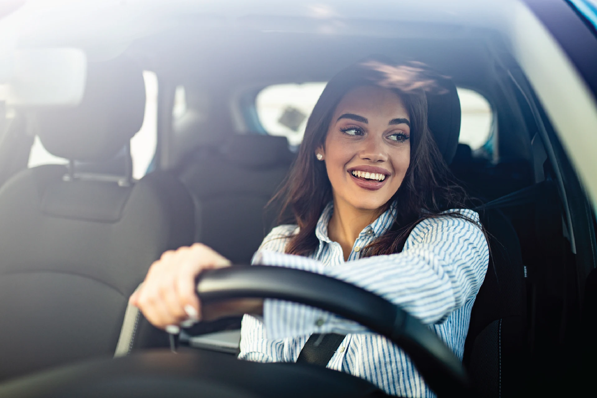 Driver gripping steering wheel in a vehicle, emphasizing automotive themes.