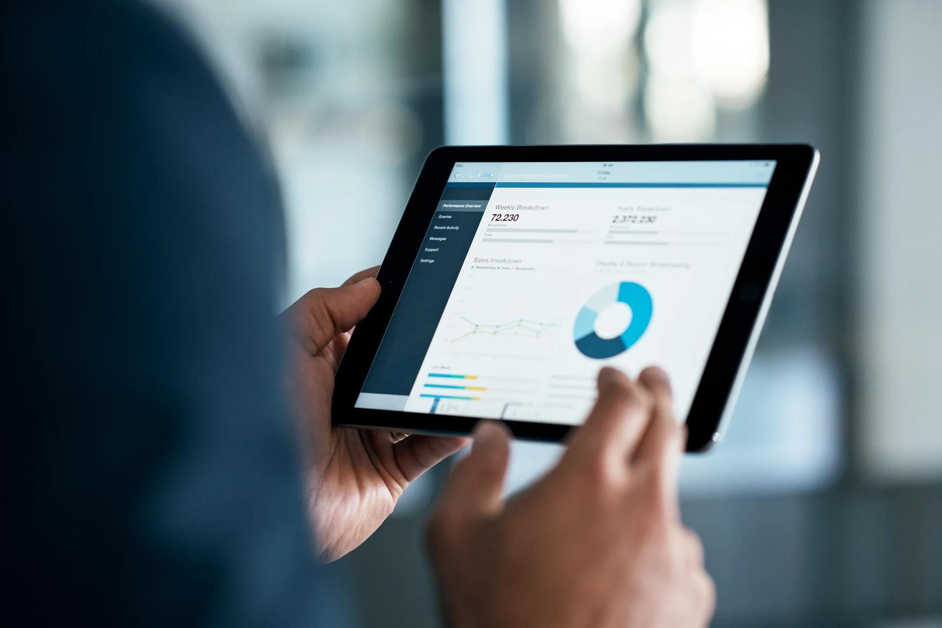 Person analyzing performance data on a tablet in a business setting