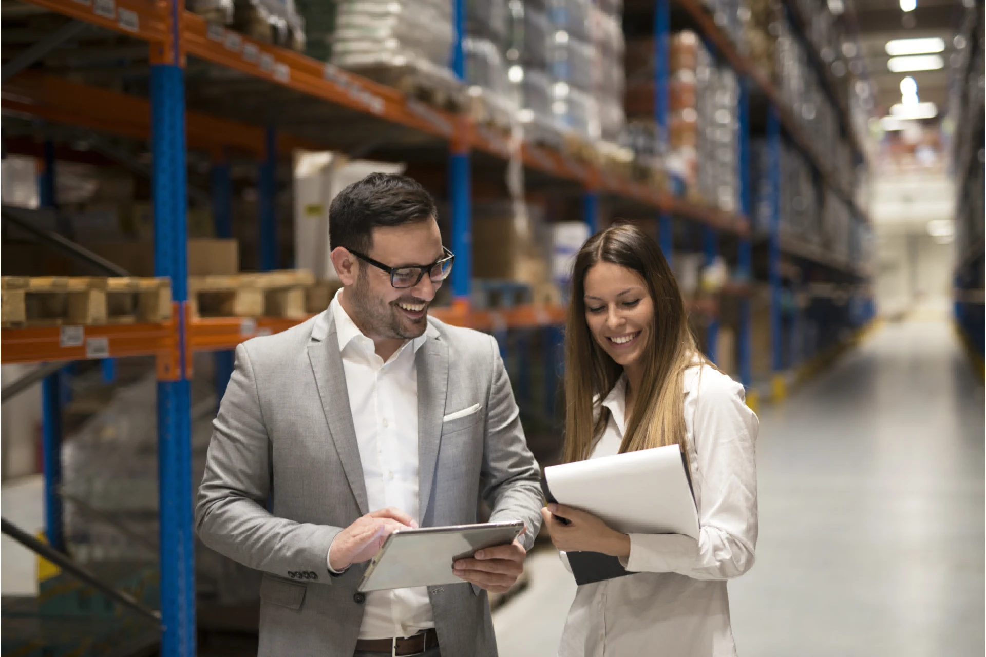 Two professionals discussing logistics in a warehouse setting
