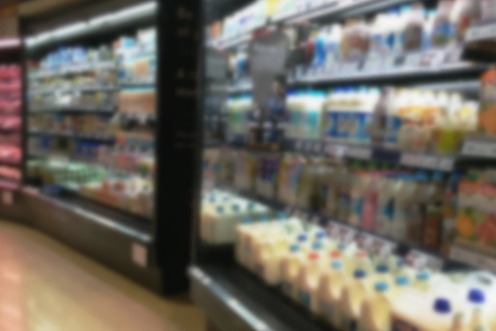 Refrigerated display case with various milk products in a retail setting
