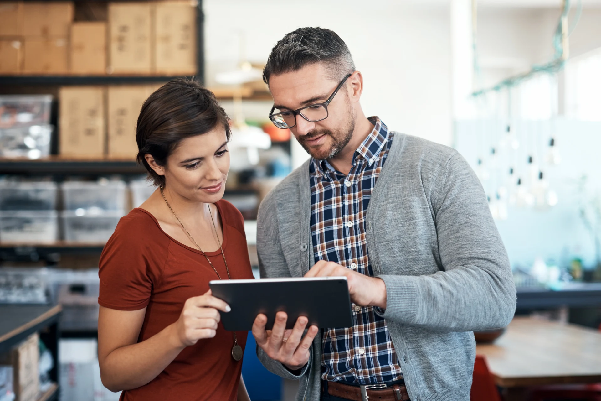 Two professionals discussing e-commerce solutions on a tablet.