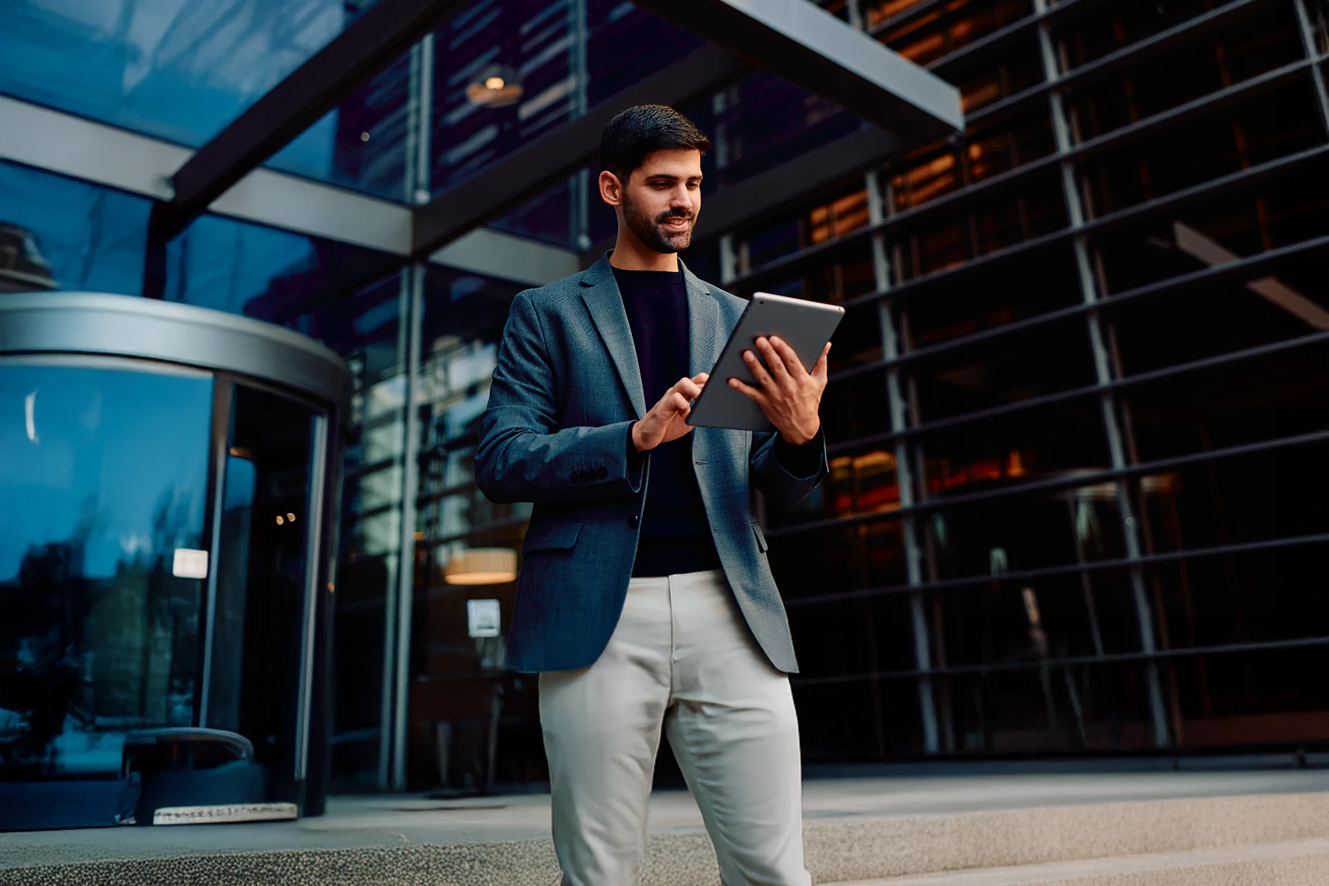Professional using a tablet outside a modern office building