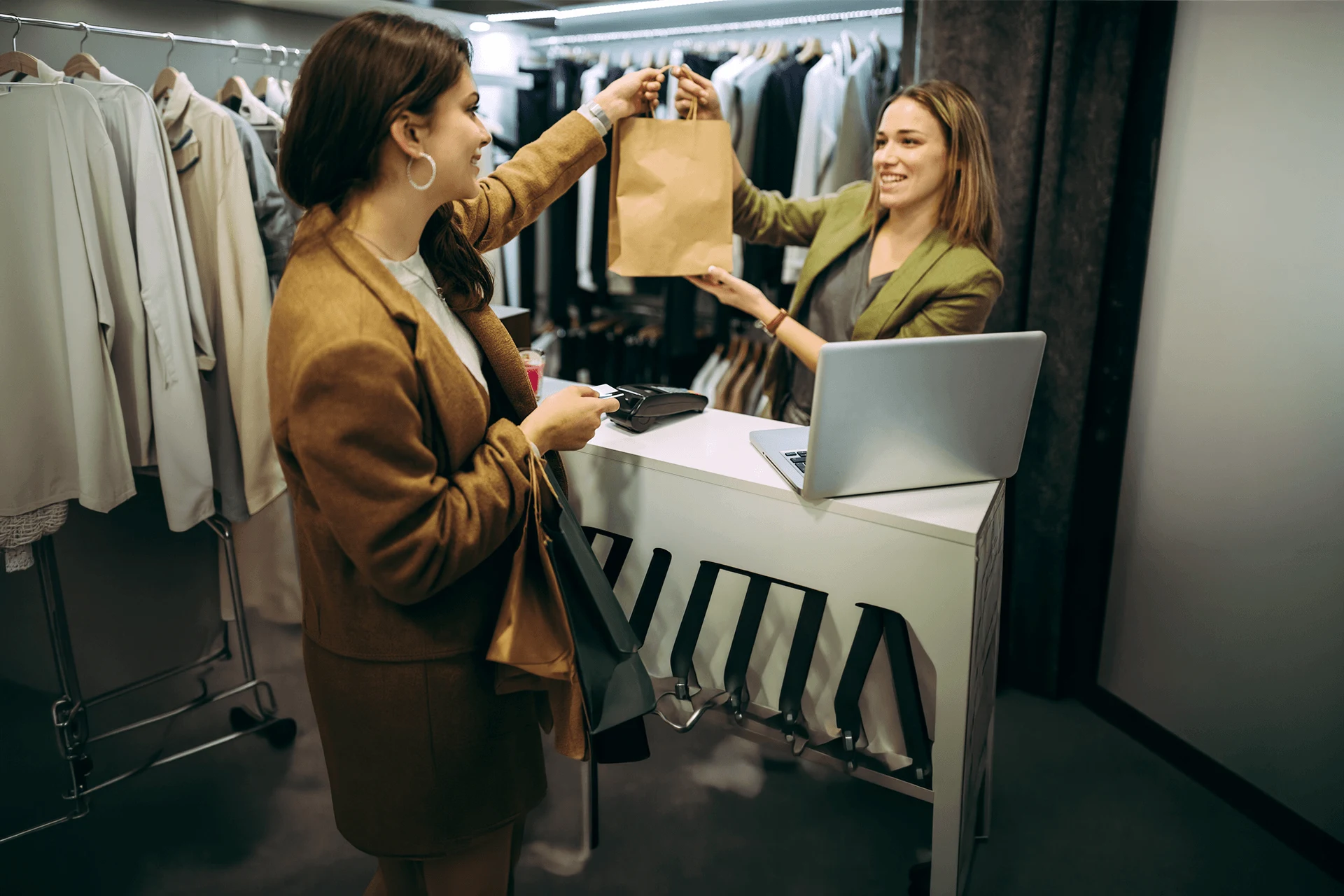 Customer receiving a shopping bag from a store associate at checkout