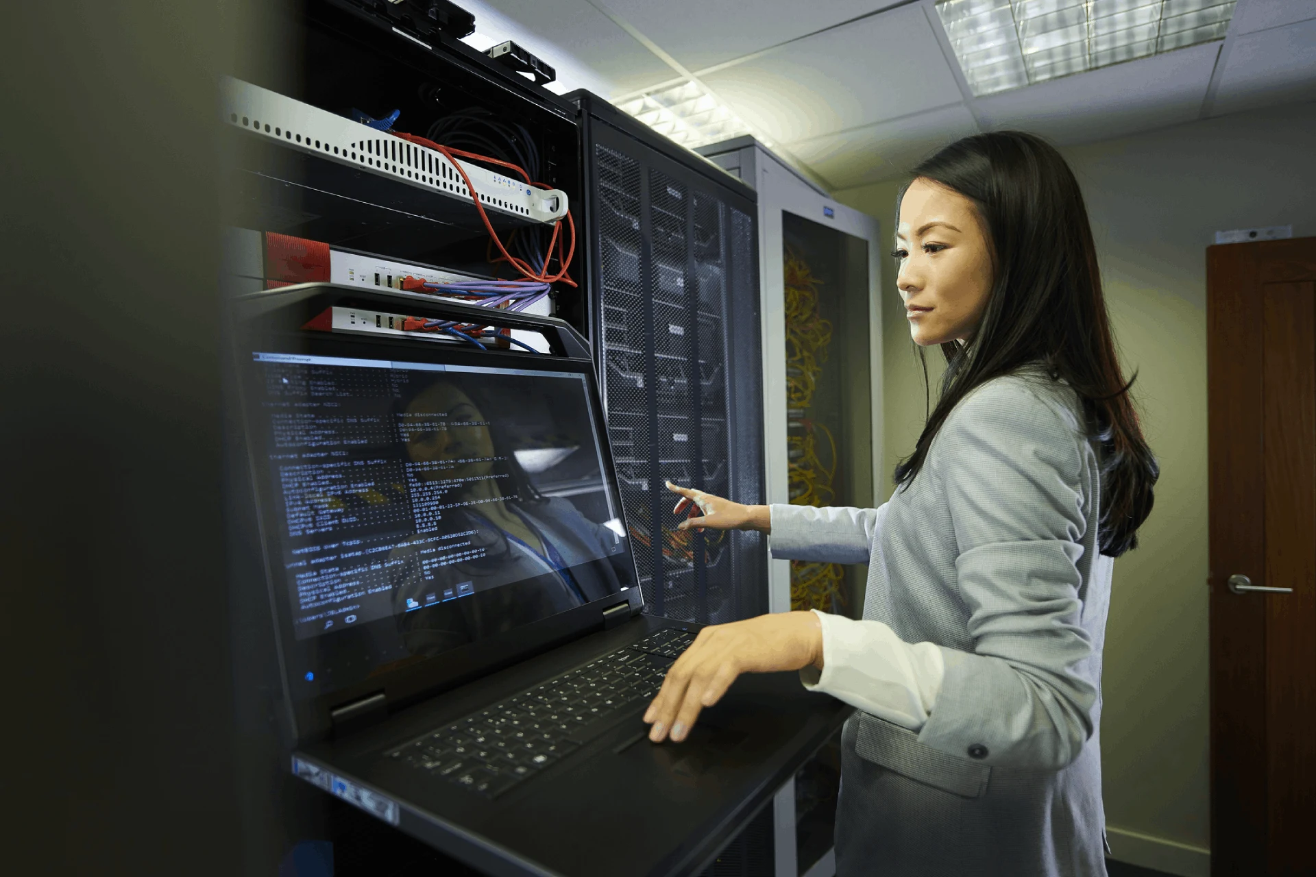 Professional monitoring data on a laptop in a server room