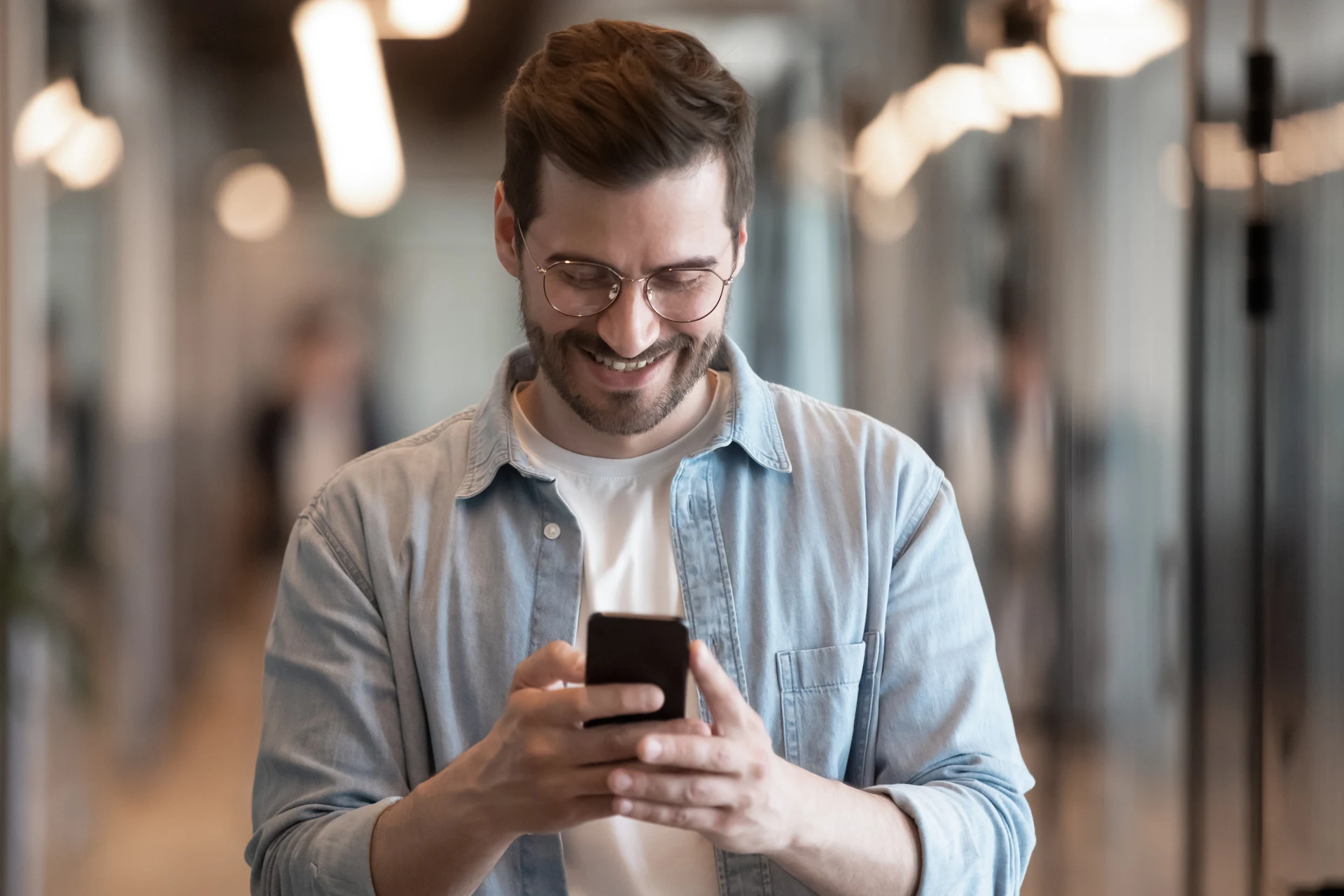 Professional using a smartphone in a modern office environment