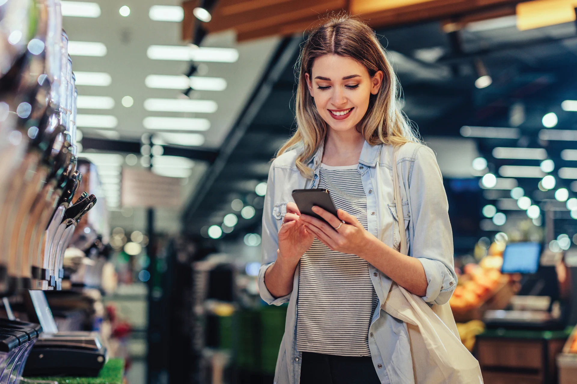 Woman using a smartphone in a retail environment during a transaction