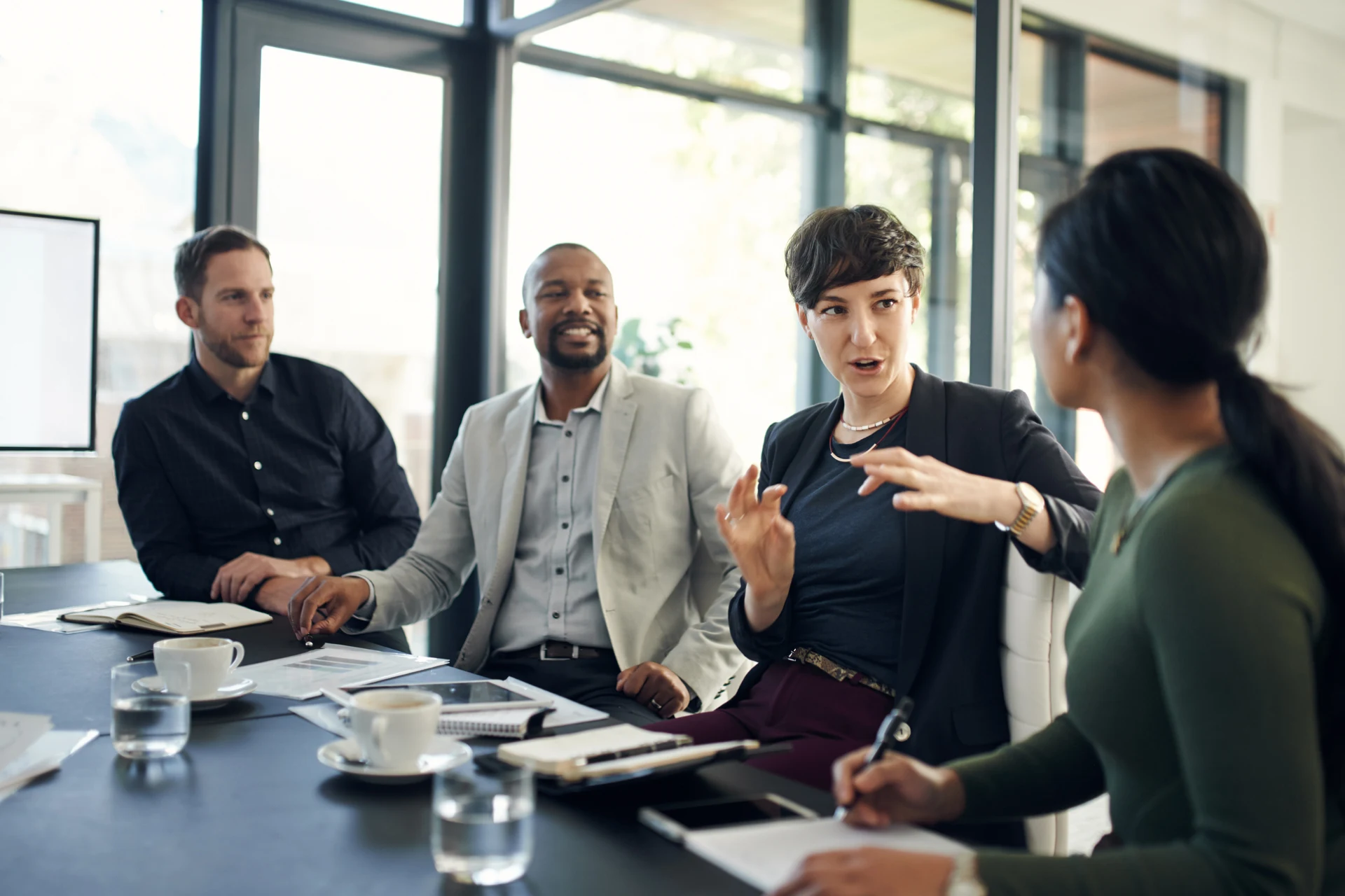 Four professionals collaborating in conference room for Guidewire testing standards