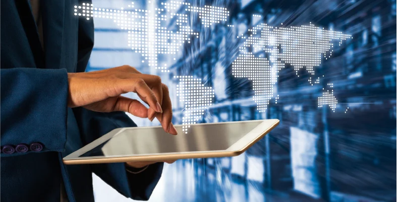 Individual using tablet computer with blurred world map graphic backdrop